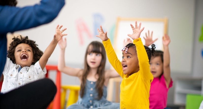 Kids with hands up in classroom