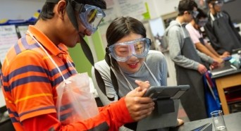 Two high school students working on a science project.