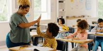 Teacher high-fiving student in classroom