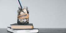 Jar of coins and pencils on a pile of school books