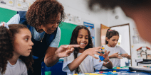 Teacher helping students at a table