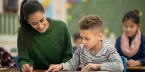 A teacher helping an elementary student with an assignment.