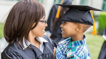 Graduating mother and son smiling at each other