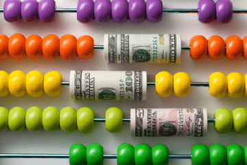 Colorful abacus interspersed with dollar bills