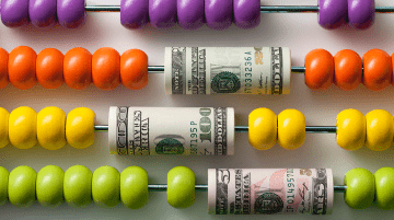 Rainbow colored abacus interspersed with dollar bills