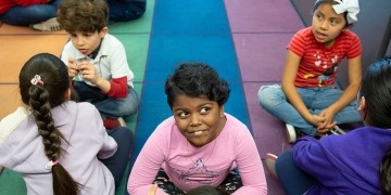 Students sit on the floor of a classroom working together