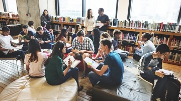 A group of students working collaboratively on an assignment in a library.