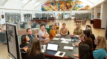 Group of educators sitting at a table in a library.