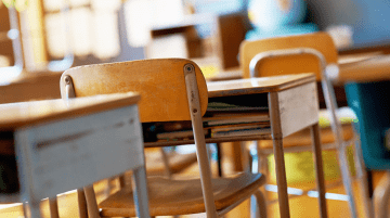 Row of empty student desks in a classroom 