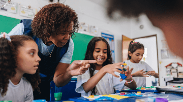 Teacher helping students at a table