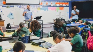A teacher presenting a lesson while a student teacher watches.