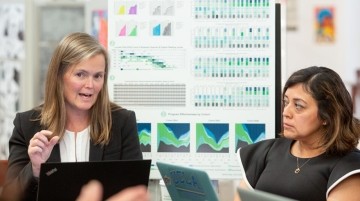 Two teachers having a discussion in a classroom.