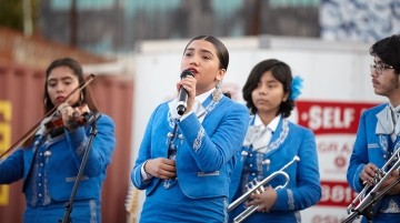 A girl singing in front of a band.