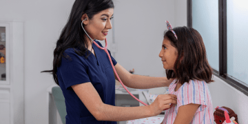 A doctor examines a young girl during an office visit.