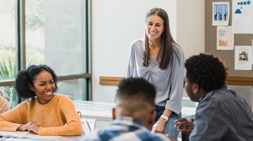 A teacher interacting with high school students.
