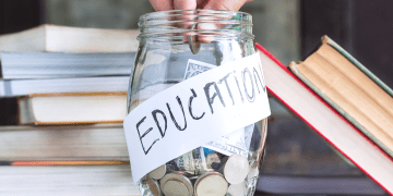 Coins being dropped into a jar labeled “Education”
