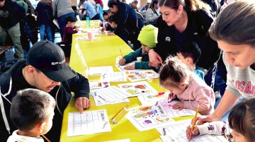A group of adults assisting students with an assignment.