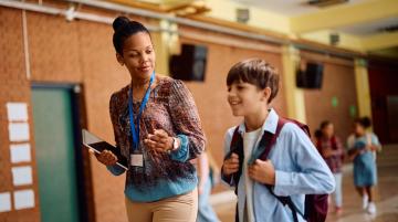 A principal talks to a student in a school.