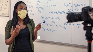 Teacher in front of whiteboard and video camera