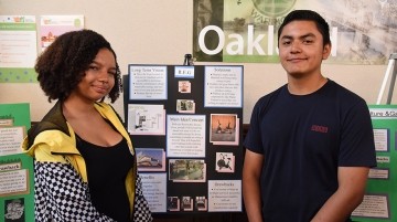 Two students standing by presentation board