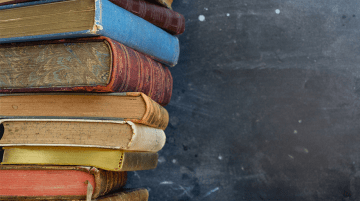 Stack of books in front of a chalkboard