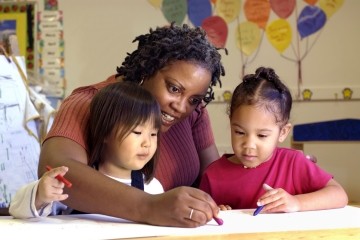 Teacher working with two young students