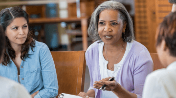 Woman speaking with other adults in group setting