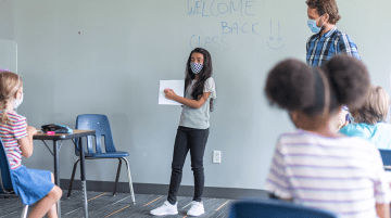 Student with mask on presenting to class