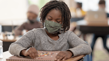 Student wearing mask while working at desk