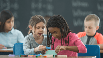 Two young students working collaboratively on a task