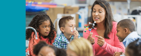 Female teacher showing students a molecule model