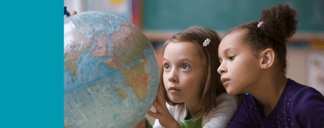 Two elementary students looking at a globe