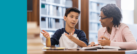 Teen student and a teacher having a discussion in a library