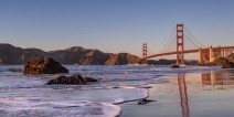 A rocky ocean shoreline with the Golden Gate Bridge in the background 