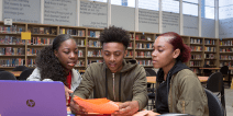 Three students collaborating in school library