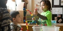 Two young students playing with an educational toy.