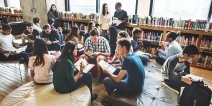 A group of students working collaboratively on an assignment in a library.