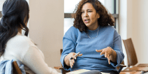 An educator and adult student having a discussion in a classroom.