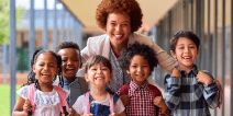 Portrait Of Multi-Cultural Elementary School Pupils With Female Teacher Outdoors At School