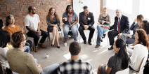 A group of adults having a discussion while seated in a circle.