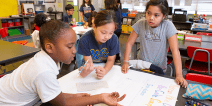 Three students working collaboratively on a school project.