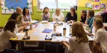 A group of educators having a discussion in a classroom.