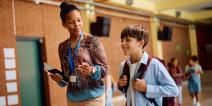 A principal talks to a student in a school.