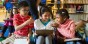 Three young students talk in a library
