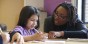 A teacher and student work together at a table