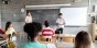 a high school student gives a presentation at the front of class
