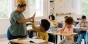 A teacher giving a student a high five in a classroom.