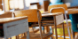 Row of empty student desks in a classroom 