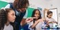 A teacher helping students finger paint.