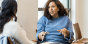 An educator and adult student having a discussion in a classroom.